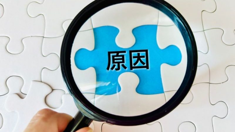 Macの故障やデータ紛失の根本的な原因を究明するイメージとして、パズルの「原因」と書かれたピースを虫眼鏡で調査する様子。