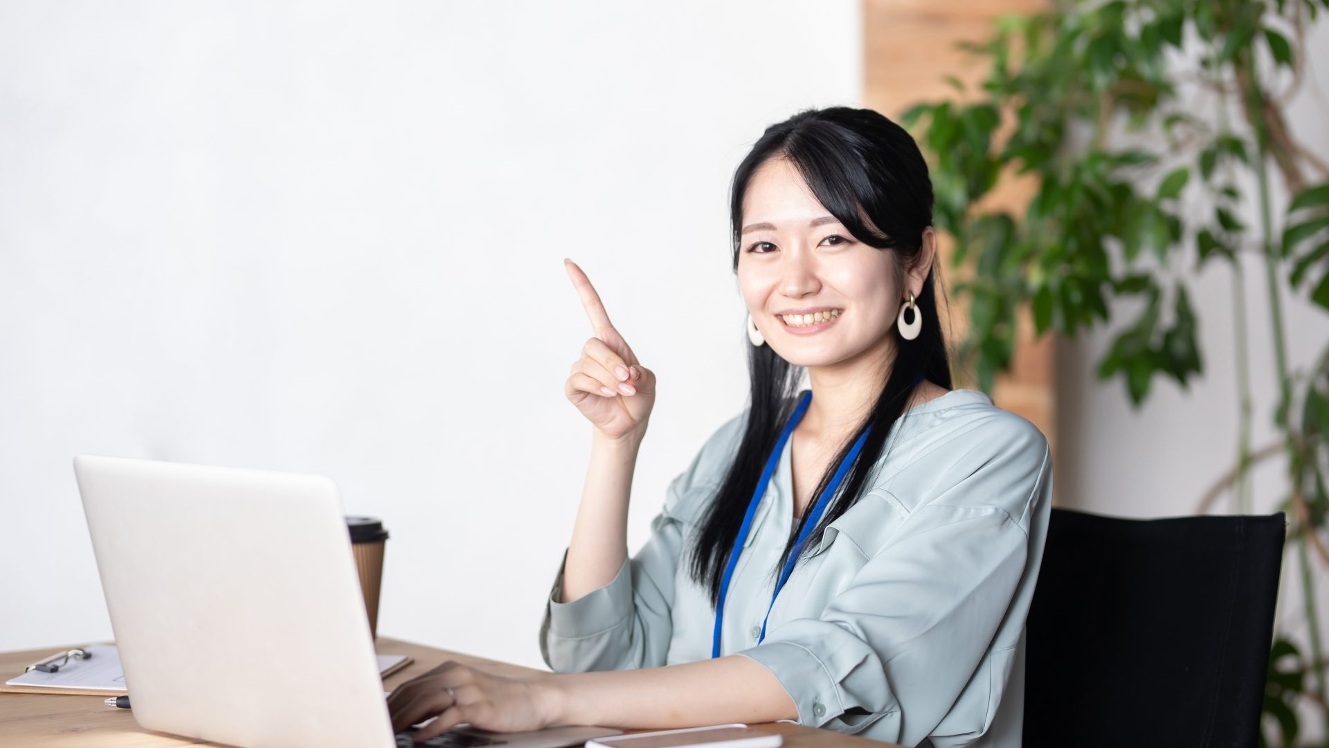 パソコン画面が真っ暗なPCトラブルの原因と対処法について、解決策を示すビジネスウーマン。