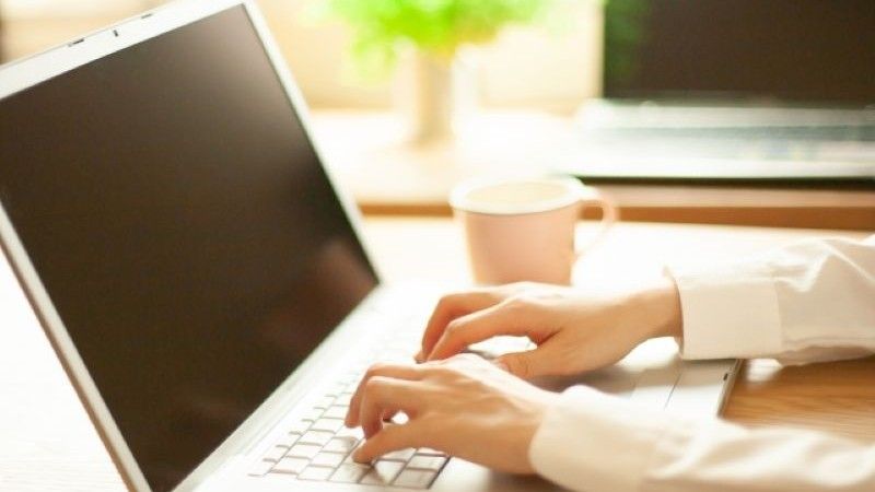 Macのデータ復旧を検討中に、自宅やオフィスでMacBookを操作しながら対処法を調べるユーザー。