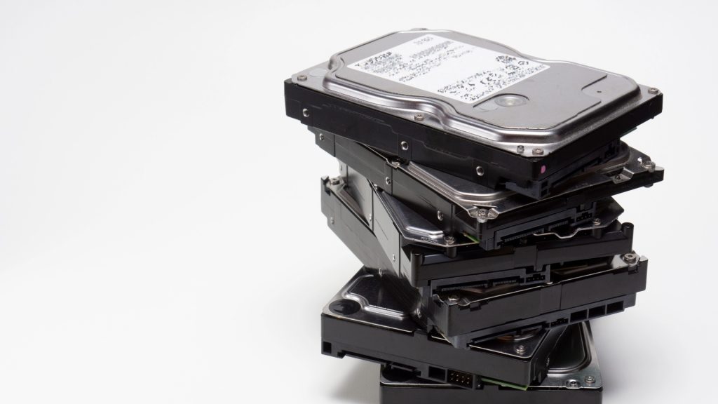 修理や廃棄、データ抽出を待つ複数のHDDが、縦に積み上げられた様子。