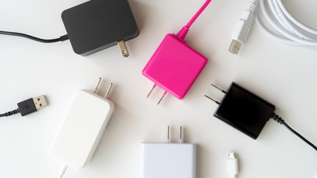 iPhoneの起動不良トラブルの確認に使用する、多様なACアダプターとUSBケーブル。充電環境の不備をチェックする際のイメージ。