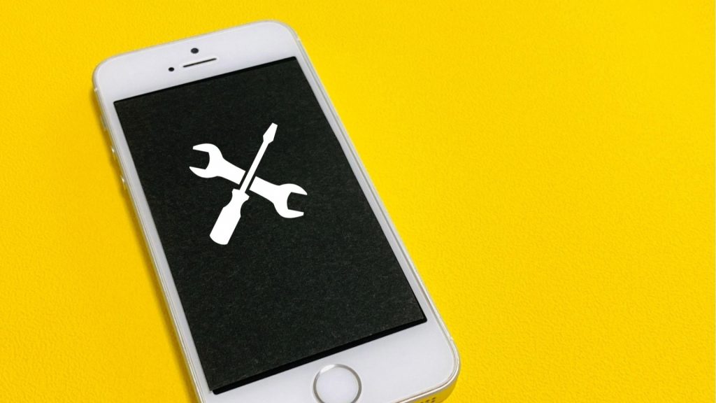 iPhoneの復元やデータ復旧サービスを象徴する、画面に表示されたレンチとドライバーのメンテナンス用アイコン。
