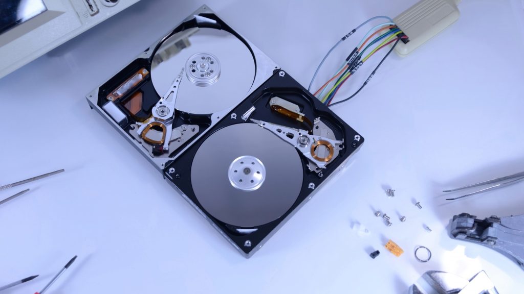 HDD修理の工程で、カバーを開けて内部のプラッタや磁気ヘッドを露出させた状態。