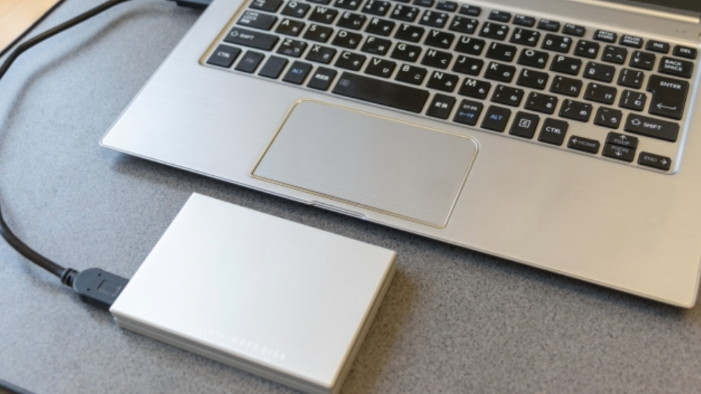 Macに接続中の外付けHDDを安全に取り外す手順。物理的なケーブルを抜く前に、OS上で「取り出し」操作が必要であることを示す接続状態のイメージ