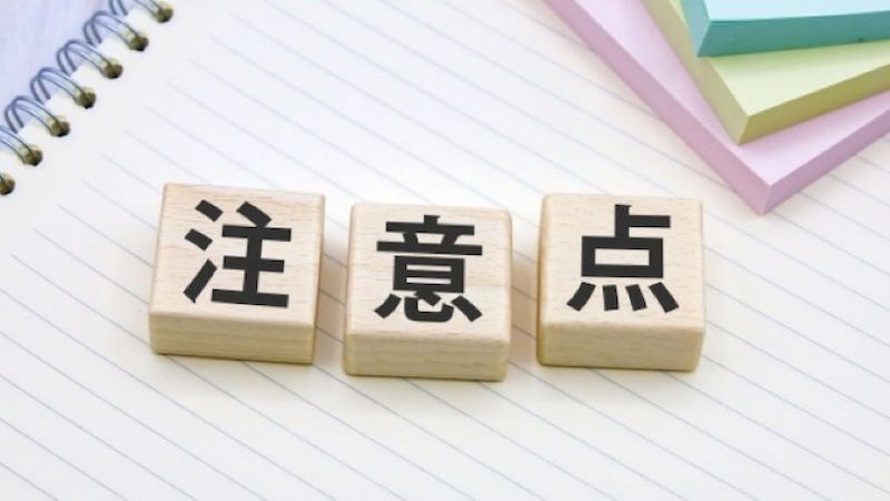 Macのデータ復旧を業者に依頼する前に確認すべき注意点を、ノートの上に置かれた3つの木製ブロックで表現している様子。