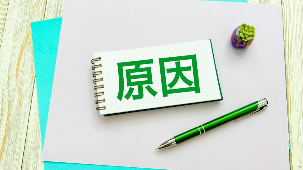 白い紙の中央に、緑色の大きな文字でスマホのデータ消失の原因を示す「原因」と書かれたメモ帳。横には緑色のペンが置かれている。